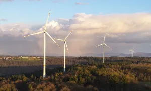 Cloudy Landscape Photography Prints: A series of wind turbines in the forest against a dramatic backdrop of clouds in the sky