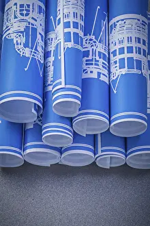 Blue Engineering Drawings Prints: Set of blue rolled engineering drawings on grey background construction concept