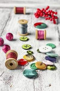 Deserted Sewing Shop Prints: Set thread, buttons, beads on the table light vintage
