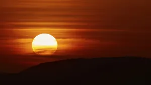 Greek Mediterranean Coastline Prints: The setting sun breaks through dramatic layers of cloud and illuminates the silhouette of a hill