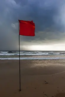 Stormy Evening Sky Prints: Severe storm warning flags on beach