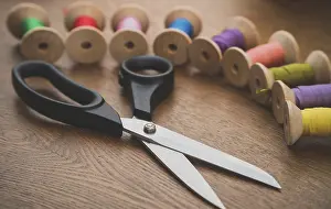Empty Workshop Scene Prints: Sewing concept. Scissors and colorful thread spools