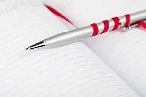Uninhabited Office Space Decor Prints: Silver pen on opened notebook with red string