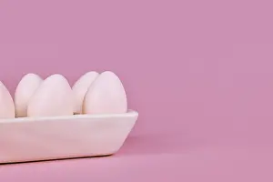 Easter Egg Prints: Simple one colored Easter eggs in egg tray on pink background with copy space