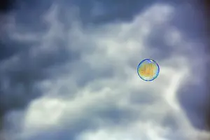 Dark Cloudy Sky Europe Prints: Single soap bubble floating in front of dark cloudy sky