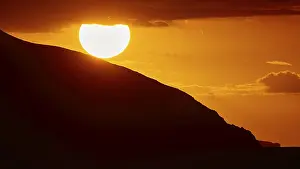 Dodecanese Island Photography Prints: Sinking sun behind a mountain slope
