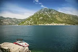 Prints of A small boat moored on the shore opposite the historic town of Perast at famous Bay of Kotor, Montenegro Montenegro Prints: Bay of Kotor Print: Perast Shoreline Scene