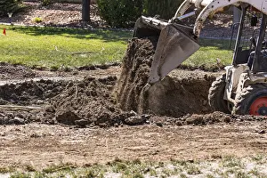 Pool Installation Process Prints: Small bulldozer digging in yard for pool installation