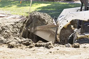 Agricultural Machinery Use Prints: Small bulldozer digging in yard for pool installation