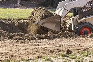 Bulldozer Construction Site Prints: Small bulldozer digging in yard for pool installation
