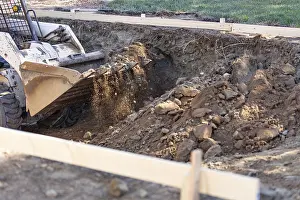 Real Estate Market Development Prints: Small bulldozer digging in yard for pool installation