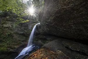 Central Europe Nature Scenes Prints: A small waterfall flows over rocks and is illuminated by the sun's rays
