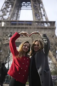 France Tourist Attraction Images Prints: Two smiling friends pose in front of the Eiffel Tower