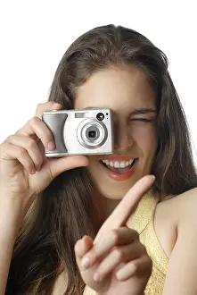Fashion Model Prints: Smiling model holding digital camera and making a shot