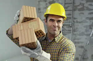 Safety Helmet Protection Prints: Smiling workman holding bricks