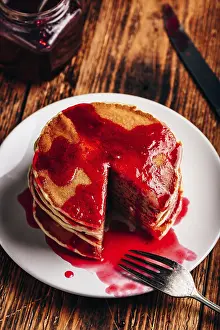 American Pancakes Prints: Stack of american pancakes with red berry jam on plate over rustic surface