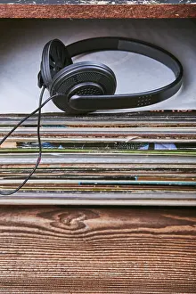 Vinyl Record Collection Prints: Stack of many black vinyl records and headphones put on the top of stack