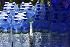 No People Waterfront Scene Prints: Stack of blue water bottles in a stall