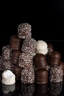 Assorted Chocolates Prints: A stack of different chocolate kisses on a dark background with a reflection
