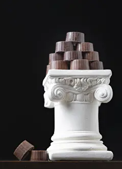 Food Still Life Composition Prints: Stack of fine artisan chocolates stacked on white pillar column