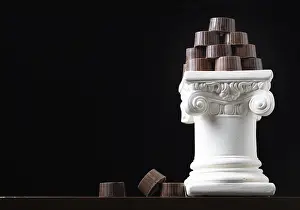 Empty Pastry Shop Prints: Stack of fine artisan chocolates stacked on white pillar column