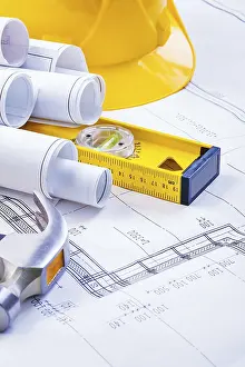 Construction Industry Equipment Prints: Stack of rolls blueprints level hammer helmet