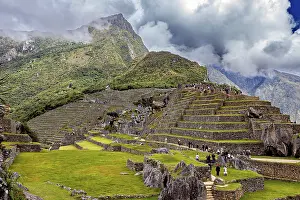 Peruvian Historic Tourist Attraction Prints: Stepped terraces with ruins against a dramatic mountain backdrop full of clouds