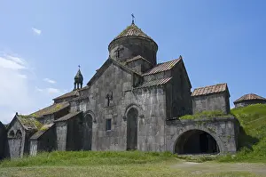 Haghpat Monastery Prints: Stone monastery with several structures and domes in front of a wide meadow