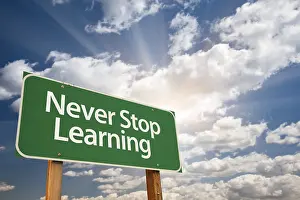 Green Road Safety Sign Prints: Never stop learning green road sign with dramatic clouds and sky