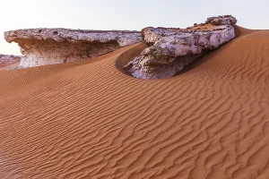 Arabian Peninsula Cliffs Prints: Striking cliffs surrounded by windswept sand structures