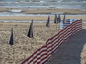Deserted Sandy Beaches Europe Prints: Striped windbreaks on the sandy beach with erected