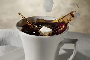Studio Shot Of Coffee Cup Prints: Sugar cubes falling into a cup of coffee