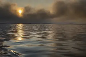 Svalbard Norway Prints: Sun breaking through clouds, reflection on slightly wavy sea surface