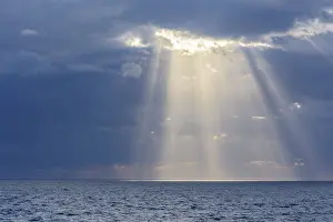 United Kingdom Coast Prints: Sun breaks through the clouds with sunrays over sea