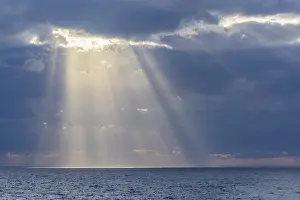 United Kingdom Beach Scene Prints: Sun breaks through the clouds with sunrays over sea