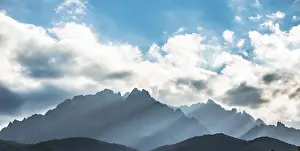 Backlit Mountain Range Prints: Sun through clouds against mountains