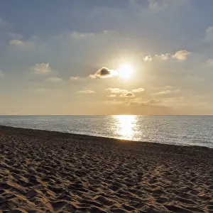 Uninhabited Coastline Scene Prints: Sunbeams in a slightly cloudy sky