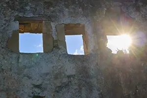 Deserted Greek Village Prints: Sunlight falls through window openings of an old