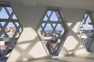 Urban Skyline View Prints: Sunlight streams through hexagonal windows