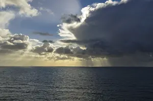 Cloudy Evening Sky Prints: Sunrays shining through clouds over the sea