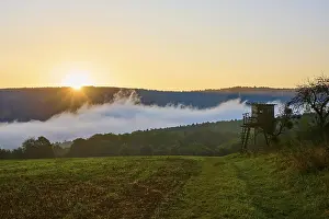Bavaria Sunrise Prints: A sunrise over a field with a raised hide