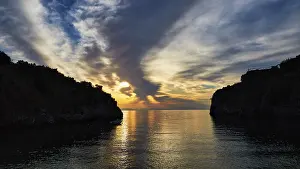 Greek Peninsula Landscape Prints: Sunrise with a view through a bay between cliffs and clouds