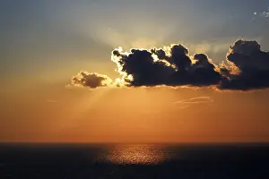 Santorini Sunset Prints: Sunset behind clouds at the sea