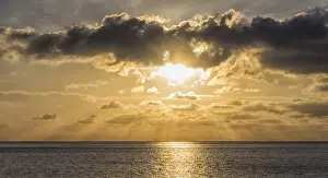 Sunset Over The Sea Prints: Sunset over the sea with the sun rays through the clouds