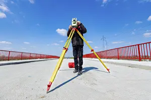 Construction Site Inspection Prints: Surveyor engineer is measuring bridge under construction