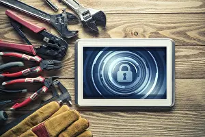 Industrial Tools Around Computer Prints: Tablet pc with security concept on screen and industrial tools around