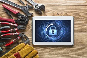 Industrial Tools Around Computer Prints: Tablet pc with security concept on screen and industrial tools around