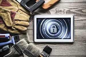 Security Concept Tablet Pc Prints: Tablet pc with security concept on screen and industrial tools around