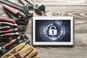 Industrial Tools Around Computer Prints: Tablet pc with security concept on screen and industrial tools around