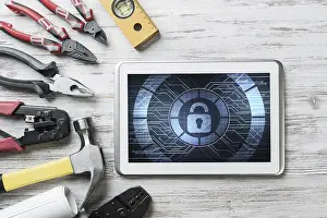 Security Concept Prints: Tablet pc with security concept on screen and industrial tools around